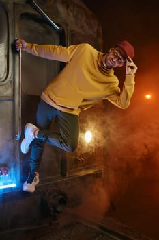 Young casual male freestyle dance performer posing for camera over urban loft studio interior