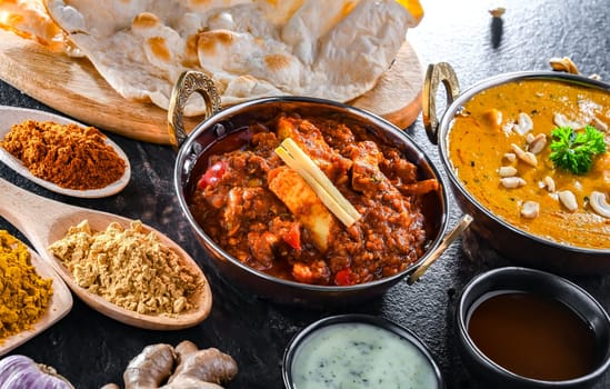 Composition with indian dishes: madras paneer, palak paneer and shahi paneer with basmati rice served in original indian karahi pots.