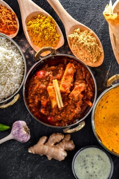 Composition with indian dishes: madras paneer, palak paneer and shahi paneer with basmati rice served in original indian karahi pots.