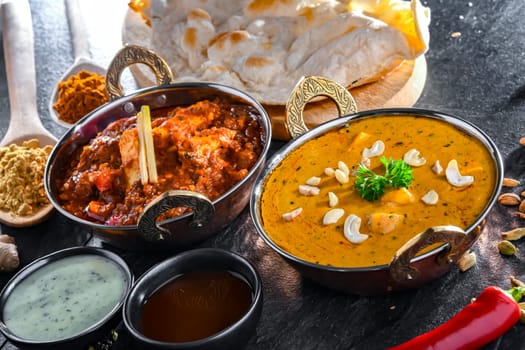 Composition with indian dishes: madras paneer, palak paneer and shahi paneer with basmati rice served in original indian karahi pots.
