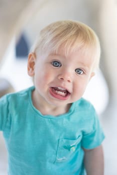 Portrait of cute little infant baby boy child playing on outdoor playground. Toddler plays on school or kindergarten yard