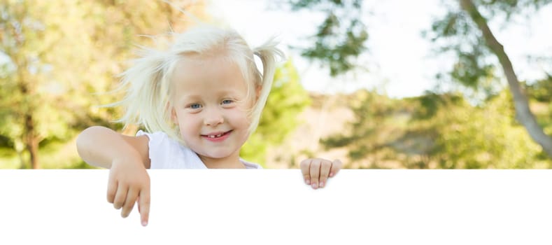 Cute Little Girl Outside Holding Edge of White Board with Room For Text.