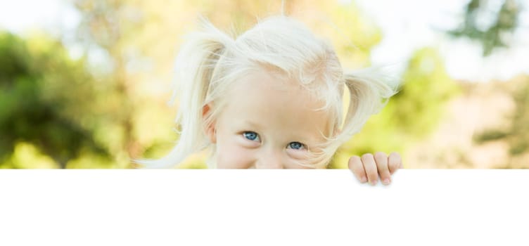 Cute Little Girl Outside Holding Edge of White Board with Room For Text.
