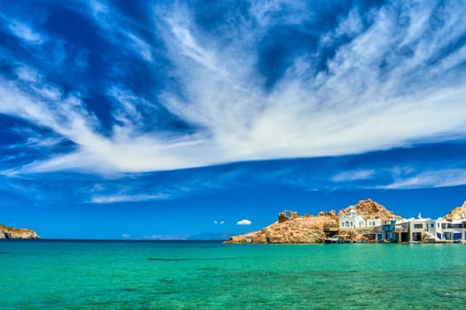 Beautiful small fishing village, traditional white fishermen houses and boat garages, turquoise clear sea water and blue sky. Firoporamos or Fyropotamos, Milos island, Cyclades, Greece. Perfect summer vacations site.