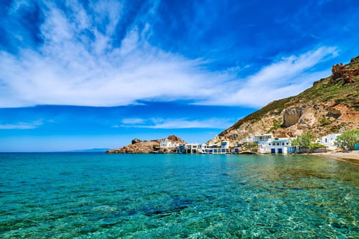 Beautiful small fishing village, traditional white fishermen houses and boat garages, turquoise clear sea water and blue sky. Firoporamos or Fyropotamos, Milos island, Cyclades, Greece. Perfect summer vacations site.