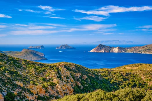 Beautiful landscape with several islets in bay, distant hazy shores, blue sea waters, great sky, sunny summer day in Mediterranean sea. Picturesque harbour, perfect Greek travel and vacation. Milos island, Greece.