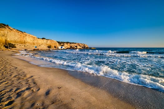 Beautiful sunset view of Fyriplaka beach, Milos island, Greece. Greek vacations, Aegean sea, high rocky landscape, azure waters, sandy beach, no people, unique location of traditional tourist destination,