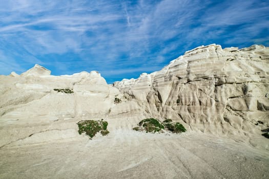 Beautiful white rocks of Sarakiniko beach, Aegean sea, Milos island , Greece. No people, empty cliffs, summer day sunshine, lunar landscape, fantastic rocks of tourist destination, deep blue sky, clouds.