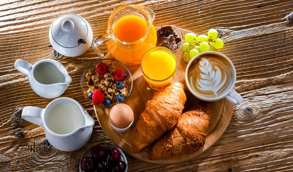 Breakfast served with coffee, orange juice, croissants and egg.