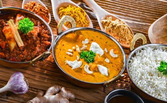 Composition with indian dishes: madras paneer, palak paneer and shahi paneer with basmati rice served in original indian karahi pots.