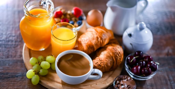 Breakfast served with coffee, orange juice, croissants and egg.