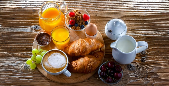 Breakfast served with coffee, orange juice, croissants and egg.