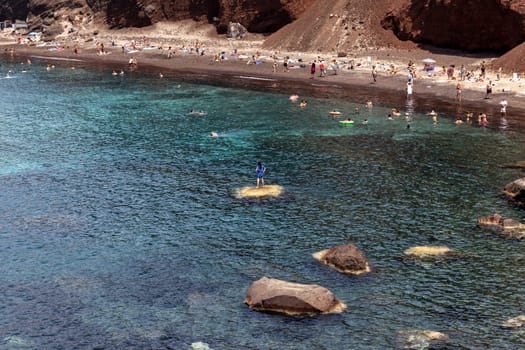 Santorini, Greece - July 01, 2021: The famous Red beach on the south coast of Santorini island, Cyclades, Aegean Sea.