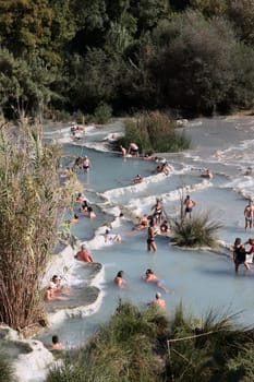 Saturnia, Italy - September 13, 2022:  People are bathing in the hot springs of Saturnia Therme, Saturnia, Tuscany, Italy