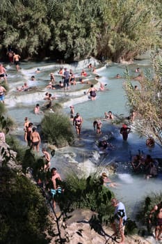 Saturnia, Italy - September 13, 2022:  People are bathing in the hot springs of Saturnia Therme, Saturnia, Tuscany, Italy