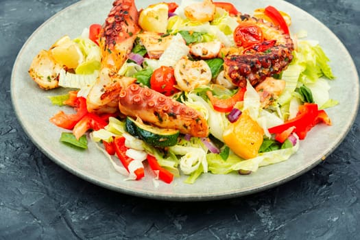 Homemade salad of vegetables and octopus tentacles. Octopus salad. Close-up.