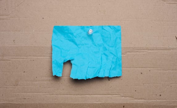 Blue sheet with tear-off edges for writing an ad on a brown background, copy space