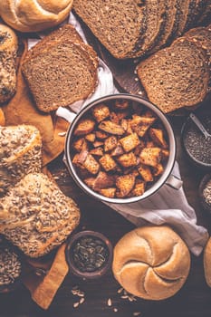 Assortment of different kind of cereal bakery - bread, pasties, buns, with healthy seeds on wooden background