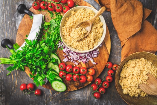 Preparing traditional oriental salad Tabouleh with couscous or bulgur, ingredients on cutting board