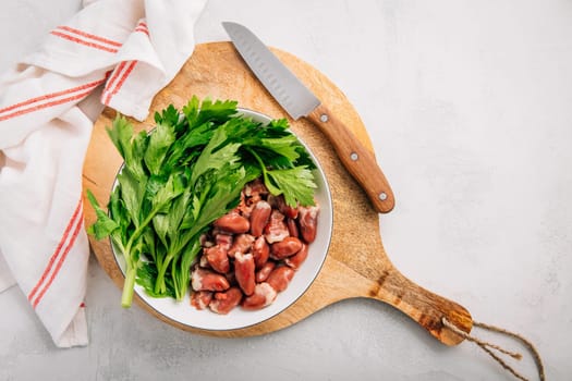 Fresh raw chicken hearts with celery leaves, reading for cooking