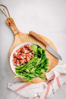 Fresh raw chicken hearts with celery leaves, reading for cooking