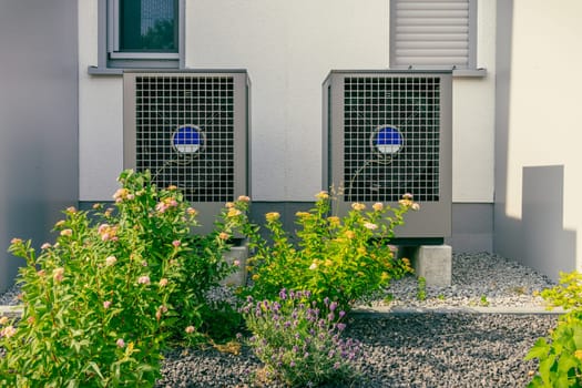 Modern air source heat pumps installed outside of new and modern city house, green renewable energy concept of heat pump