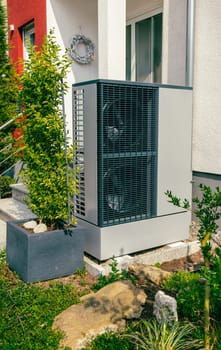 Modern air source heat pump installed outside of new city house, green renewable energy concept of heat pump