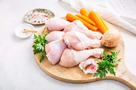 Raw chicken drumsticks with vegetables ans spices prepared for cooking