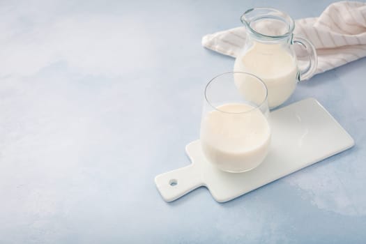 Buttermilk, kefir, yogurt with probiotics, ayran in glass and jar. Probiotic cold fermented dairy drink. Trendy food and drink.