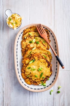 Homemade potato pancakes (Kartoffelpuffer) with cabbage salad and green onions