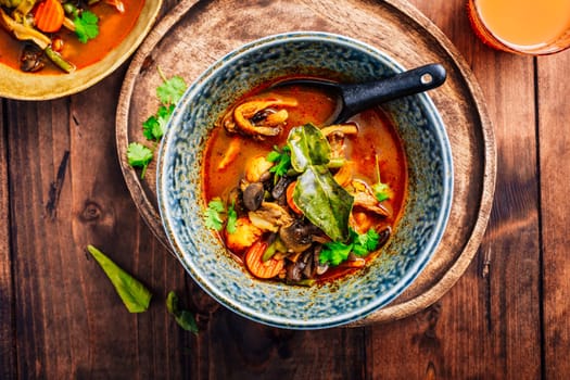 Thai red vegetarian curry with mushrooms and vegetables on wooden table