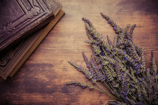 Vintage background with bunch of lavender a old books on wooden background