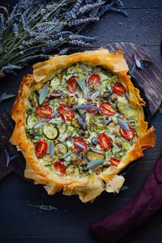 Delicious vegetarian summer quiche with zucchini, tomato, mushrooms, sage and lavender with phyllo pastry