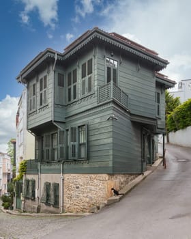 Facade of colorful wooden residential building painted in green, and window with wooden shutters, at an alley suited in Kuzguncuk neighborhood, Uskudar district, Istanbul, Turkey