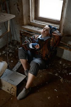 Girl in old dirty, ragged clothes smoking cigarette, selective focus. Disadvantaged homeless teenager concept