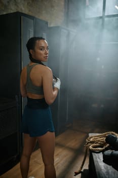 Healthy strong female boxer portrait over old vintage locker room at gym with old vintage loft interior