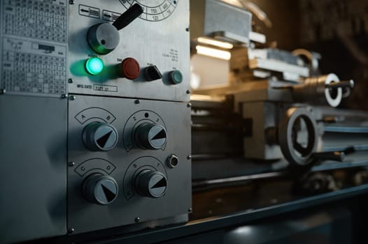 Operation panel with buttons, knobs and switches of professional lathe turning machine closeup view
