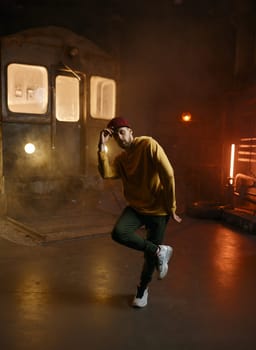 Male breakdancer wearing casual clothes dancing at the subway station