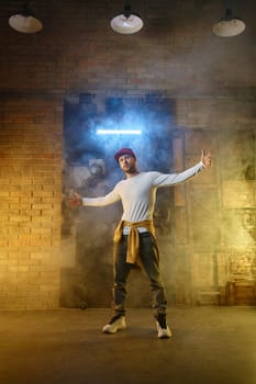 Contemporary hip hop freestyle dancer posing for camera standing in cool position gesturing with wide spread arms get ready for dance challenge competition