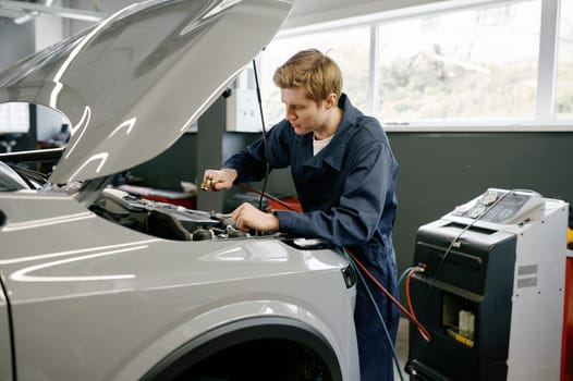 Male technician checking car air conditioning climate system. Professional diagnostics and refilling auto conditioner