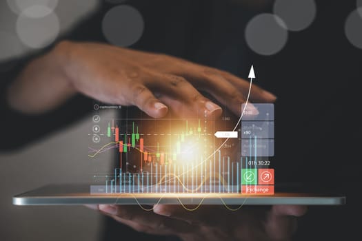 Businessman showcasing a virtual hologram of financial data with a rising arrow on a dark background using a tablet. Stock market growth and strategy concept. Technology and data analysis is solution