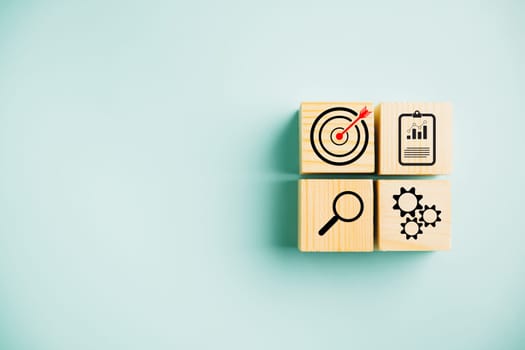 Wooden cube block step with Action Plan, Goal, and Target icons. Success and business target concept. Project management and company strategy on a blue background.