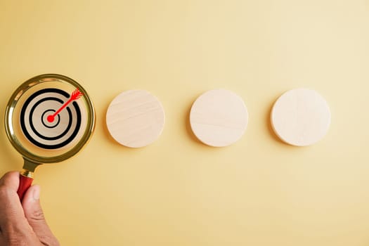 A magnifier glass magnifying a target board, emphasizing importance of hitting business objectives. Against with copy space, it symbolizes the pursuit of innovation and charting a winning path.