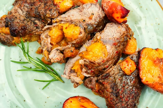 Succulent beef steak with peach in fruit marinade. Close-up.