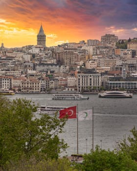 Skyline of European side of Istanbul with ferry boats sailing in Bosphorus strait, Galata Tower in the far end and cloudy sky in a spring day before sunset, Turkey