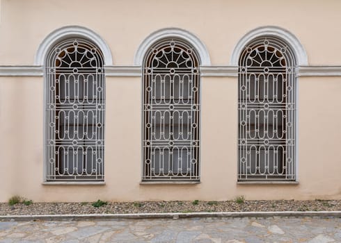 Three adjacent decorated wrought iron arched windows at the courtyard of Dolmabahce Palace, Besiktas district, Istanbul, Turkey
