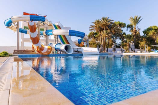 Small aquapark sliders with pool and palm trees at the morning, Tunisia