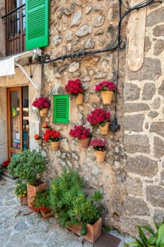 Narrow street in the Valldemossa with lots of ubiquitous flowers. Architectural treasures - Magic of Valldemossa's historic center and its Mediterranean architecture. Balearic Islands Mallorca Spain.