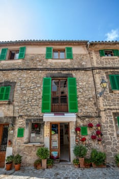 Narrow street in the Valldemossa with lots of ubiquitous flowers. Architectural treasures - Magic of Valldemossa's historic center and its Mediterranean architecture. Balearic Islands Mallorca Spain.