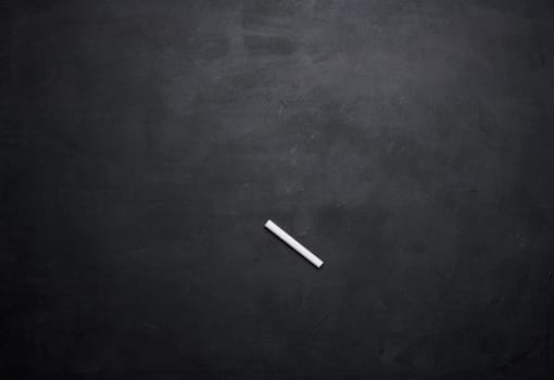 Empty black chalk board and white chalk stick